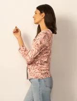 Cardigan de punto con estampado de mariposas en tonos grises y blancos. Presenta cuello redondo, cierre frontal con botones y mangas tres cuartos con puños acanalados.