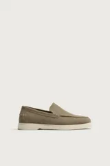 Mocasines casuales para hombre, fabricados en piel con acabado en serraje color marrón, de corte liso con detalle de bordón y suela blanca a contraste.