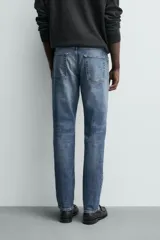 Pantalón de jean corte slim fit, color gris con efecto lavado. Presenta diseño de cinco bolsillos, cierre frontal con cremallera y botón, y tejido elástico.