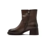 Bota de caña media confeccionada en cuero vacuno color marrón oscuro, con taco cuadrado robusto y suela track dentada.