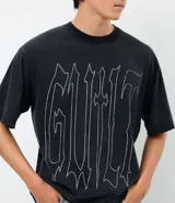 Remera de corte boxy en algodón color negro, con cuello redondo, mangas cortas y estampa frontal con lettering Guilt en color blanco.