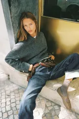 Jersey de punto suave con cuello en V y manga larga, con detalle de botones metálicos en los puños.