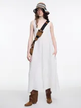 Vestido largo blanco de lino, con escote en V y tajo delantero. Presenta una costura central con pespunte de contraste.