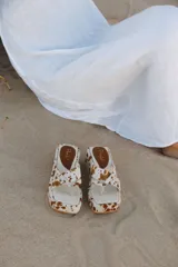 Sandalias con plataforma y capellada de cuero con estampado animal print de vaca en tonos marrón y blanco.