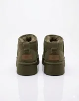 Botas tipo pantubota color camel, confeccionadas en material gamuzado con interior de piel sintética y suela de plataforma plana.