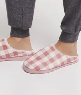 Pantufla cerrada de mujer con estampado de cuadros en tonos rosado y blanco, con interior forrado en material suave y suela de goma.