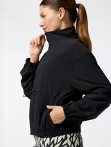 Campera cortavientos Bsoul de color negro, con cuello alto, cierre frontal y cordón ajustable en la cintura.