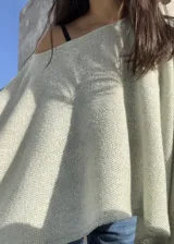 Poncho de hilo liviano en color verde claro, con diseño sin cuello y caída fluida. Es una prenda versátil de media estación con textura tejida.