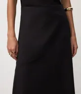 Pollera midi evasé negra, confeccionada en bengalina, con un recorte horizontal en la parte delantera.