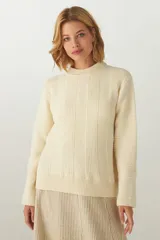 Buzo de tejido de punto industrial color crema, con cuello a la base. Prenda liviana y cómoda, de uso casual. Tejido en 100% lana fina sin teñir.