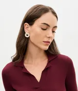 Par de aros tipo botón circulares con diseño cutout en el centro y filas de zirconias brillantes aplicadas, con baño color oro claro.