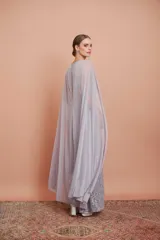 Vestido largo de encaje color plata con brillos y cuello halter. Incluye capa de gasa larga.