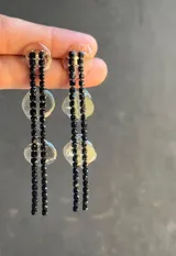 Par de aros largos con base de resina transparente y tiras de strass doradas.