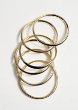 Pulsera rígida tipo brazalete de diseño multianillo en color dorado.