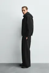 Pantalón de corte wide fit confeccionado en tejido técnico con efecto neopreno. Presenta cintura elástica ajustable con cordón, perneras anchas con costura frontal, bolsillos laterales y bolsillos traseros de plastrón.