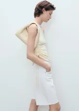 Short de denim blanco de tiro medio, diseño de corte recto y cinco bolsillos, con trabillas para cinturón y bajo deshilachado.