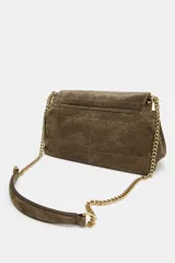 Bolso de hombro confeccionado en piel de ante, con diseño estructurado y solapa frontal con cierre imantado. Presenta pespuntes decorativos en el cuerpo y una correa combinada de cadena metálica dorada y piel.