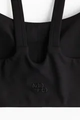 Top deportivo negro de soporte medio, con breteles dobles y espalda deportiva.