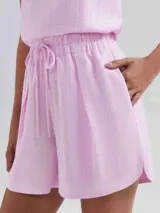 Short de cintura alta con elástico y cordón ajustable, confeccionado en tela ligera con textura, de corte holgado y ruedo redondeado.