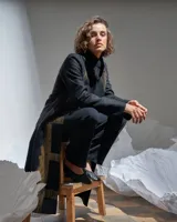 Tapado negro de paño de lana con corte recto, bolsillos laterales y estampado serigráfico de ventanas en color cobre.