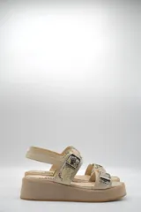 Sandalia de plataforma color beige claro, con dos tiras anchas con estampado de piel de serpiente (pitón) y hebillas metálicas.