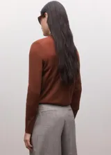 Jersey de lana color marrón tostado, con mangas largas y cuello alto con solapas de camisa superpuestas en tono oscuro.