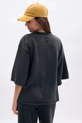 Remera oversize de manga corta con efecto lavado en color negro, cuello redondo y terminaciones deshilachadas.