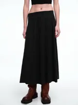 Falda midi de silueta amplia y corte evasé, confeccionada en tela fluida de color negro. Presenta una cintura limpia en el frente y elástico en la parte posterior para mayor comodidad.