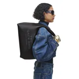 Cartera tipo hobo Marc Jacobs modelo The Sack Bag, confeccionada en cuero negro con textura granulada. Presenta el nombre del modelo y la marca grabados en el frente, con una correa de hombro integrada y diseño minimalista.