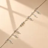 Pulsera de cadena fina en plata 925, decorada con múltiples dijes colgantes en forma de peces y pequeñas esferas metálicas intercaladas.