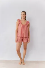 Conjunto de pijama de algodón estampado, compuesto por una musculosa de escote recto con breteles con volados y un short con elástico en la cintura y terminación con volado.