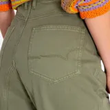 Pantalón estilo cargo de tiro alto, confeccionado en algodón orgánico. Presenta diseño con detalles de patchwork en dos tonalidades de verde, cierre tradicional, bolsillos frontales y refuerzos en las rodillas.