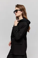 Blazer sastrero negro de calce relajado, con solapa clásica, cierre de un botón frontal y bolsillos laterales con tapa.