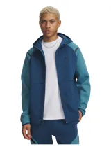 Campera deportiva con capucha y cierre frontal completo, confeccionada en tejido polar de doble punto elástico y transpirable. Presenta diseño de bloques de color en tonos azul, mangas raglán, bolsillos laterales con cierre y logo de la marca en el pecho.