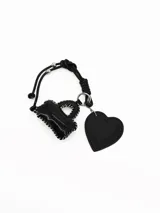 Llavero de cuero sintético negro con cordón ajustable, un dije en forma de cartera pequeña con costuras blancas y un dije en forma de corazón con la frase grabada 'Lovely Moments'.
