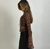 Top marrón con estampado animal print, escote en V con volados y mangas largas acampanadas. Se ata en la parte delantera con tiras.