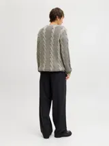 Sweater de punto con manga larga, cuello redondo y fit relajado. Presenta un diseño con textura acanalada y trenzas verticales, con puños y cuello acanalados.