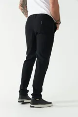 Pantalón chino color beige, de corte slim, con bolsillos laterales y traseros. Se ajusta a la cintura con cinturón de cuero marrón.