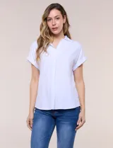 Blusa blanca de algodón y viscosa, con cuello camisero, escote en V y mangas cortas con vuelta.