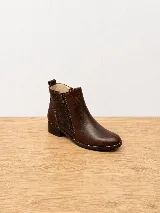 Botinetas de cuero azul marino, con diseño de doble cierre lateral y talón con textura en relieve tipo cocodrilo. Cuentan con taco bajo y suela de goma.