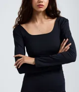 Vestido midi de manga larga con escote cuadrado, confeccionado en microfibra de poliamida y elastano. Presenta un diseño ajustado al cuerpo con una abertura lateral en el ruedo.