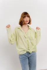 Camisa color crema de algodón con cuello camisero, botones y detalles de encaje en el escote.