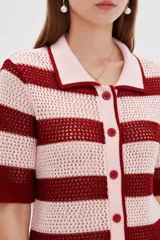 Top de punto calado con rayas horizontales en color rosado y rojo, de manga corta, con cuello tipo polo y cierre frontal con botones.