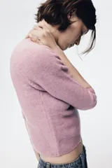 Jersey de punto liso con cuello subido y mangas tres cuartos, con terminaciones en rib.
