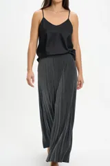 Pantalón tipo palazzo de corte amplio y fluido, confeccionado en tela con acabado brillante plateado y textura plisada. Presenta cintura elástica para un ajuste cómodo.