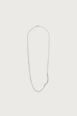 Collar de cadena con eslabones metálicos plateados y colgante lateral rígido y curvado a contraste.