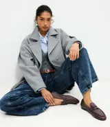 Mocasín femenino estilo penny loafer confeccionado en cuero, con suela baja y diseño estructurado con recorte en el empeine.