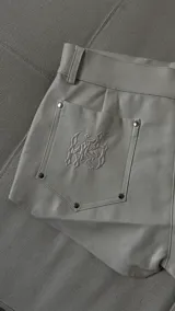 Short mini de ecocuero color crudo, con bolsillos traseros y detalle de bordado en uno de ellos.