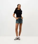 Blusa de morley color marfil con calce ajustado, cuello redondo, mangas cortas y detalle de puntilla en los puños.
