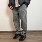 Jean de corte baggy con efecto lavado en tono gris, de tiro medio y ajuste clásico con bolsillos laterales.